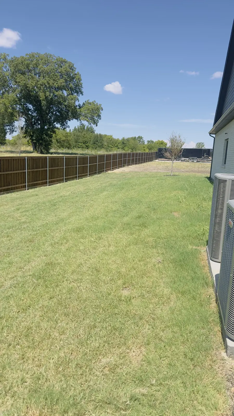 Cedar fence along a green lawn by Aesthetic Gates & Fence in Navarro County, Texas