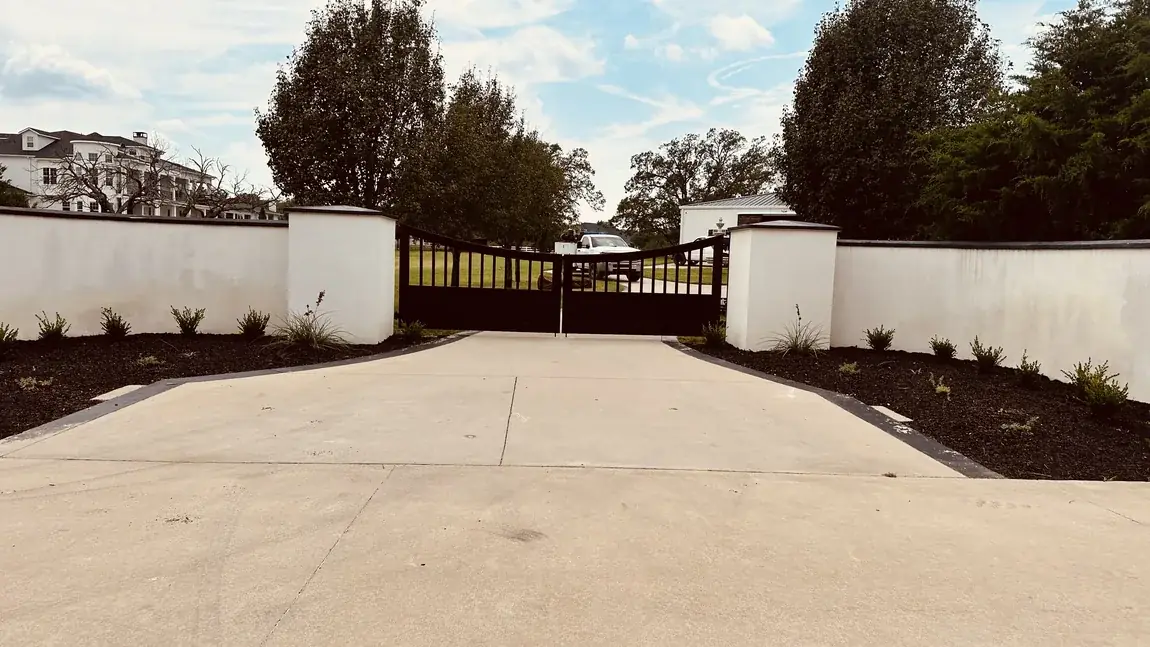Double drive gate in a white wall by Aesthetic Gates & Fence in Navarro County, Texas