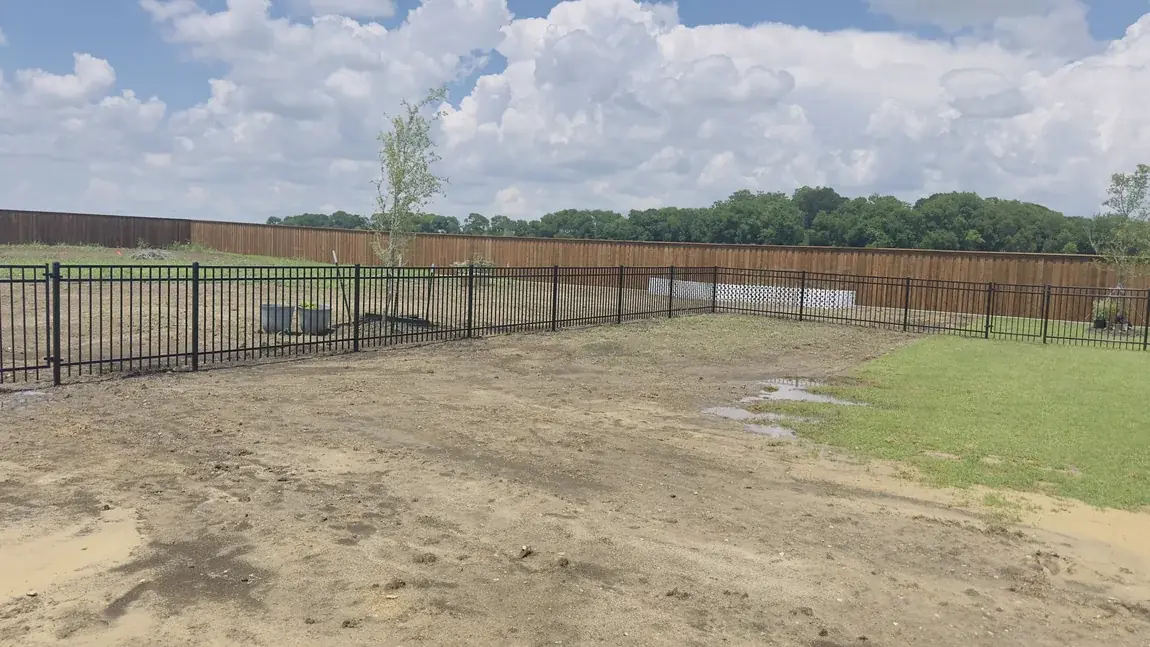 Iron and wood fence on a large lot by Aesthetic Gates & Fence in Navarro County, Texas