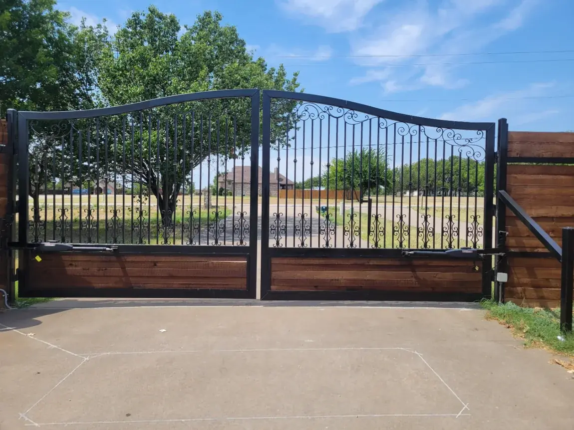 Iron gate against cedar fence by Aesthetic Gates & Fence in Navarro County, Texas