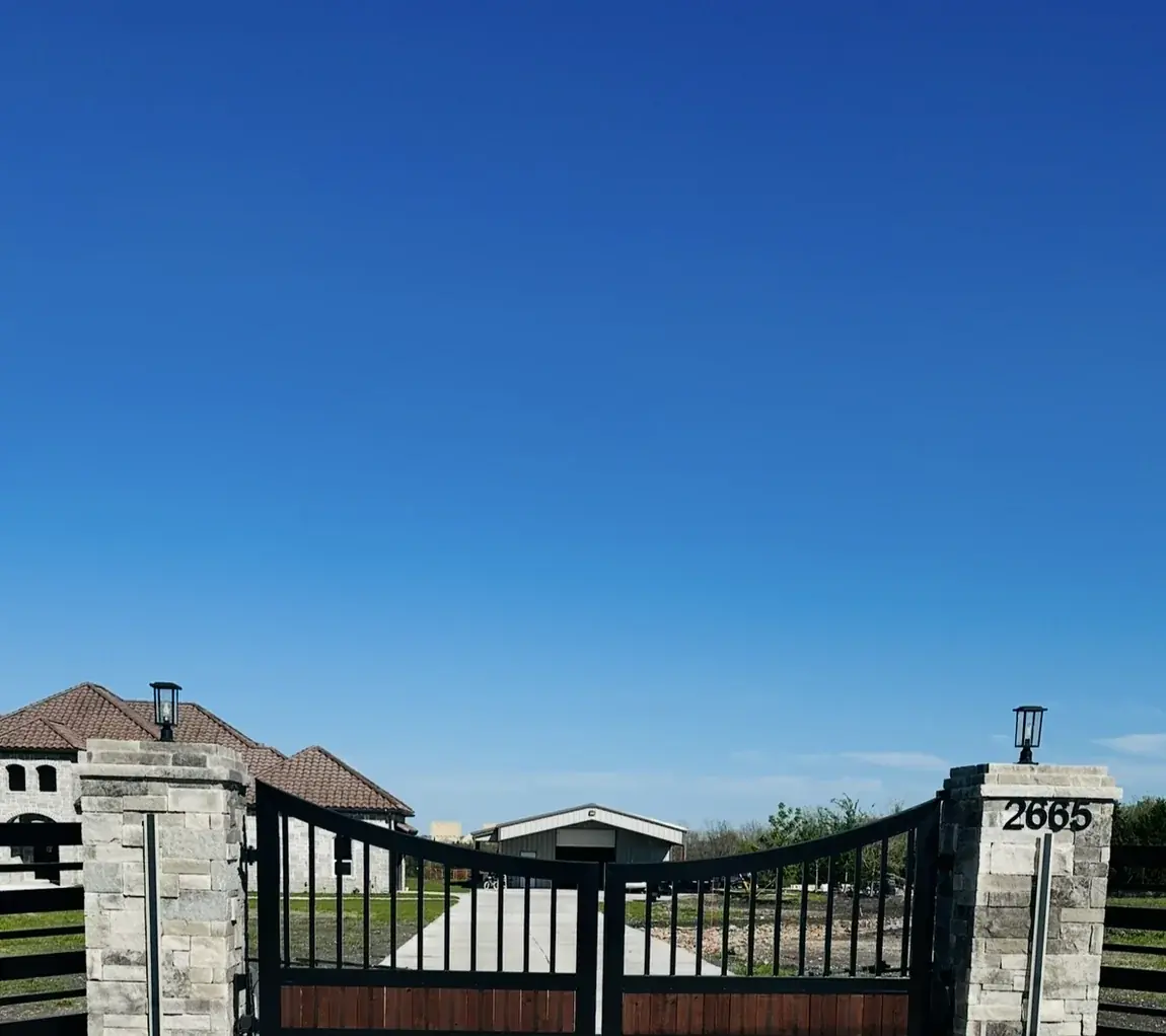 Iron gate on stone columns by Aesthetic Gates & Fence in Navarro County, Texas