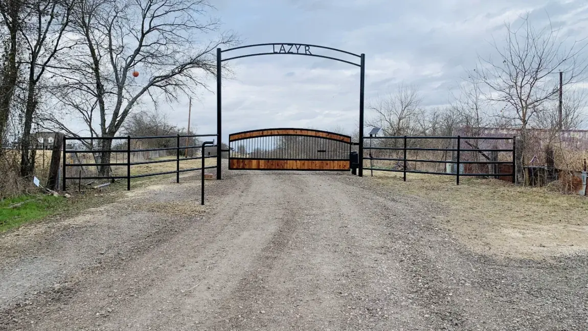 Ranch arch over a gravel drive by Aesthetic Gates & Fence in Navarro County, Texas