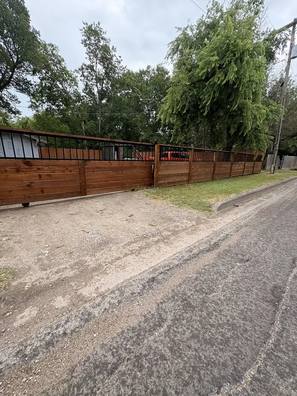 Wood fence on a gravel drive by Aesthetic Gates & Fence in Navarro County, Texas