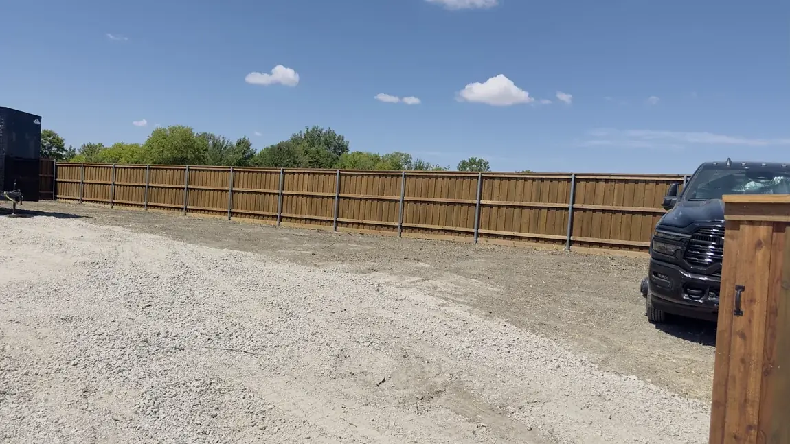 Wood fence beside a gravel drive by Aesthetic Gates & Fence in Navarro County, Texas