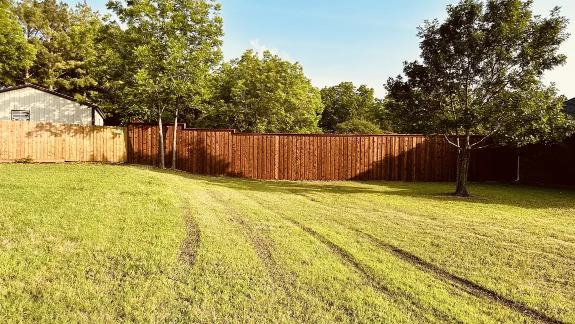 Wood fence through a shaded yard by Aesthetic Gates & Fence in Navarro County, Texas